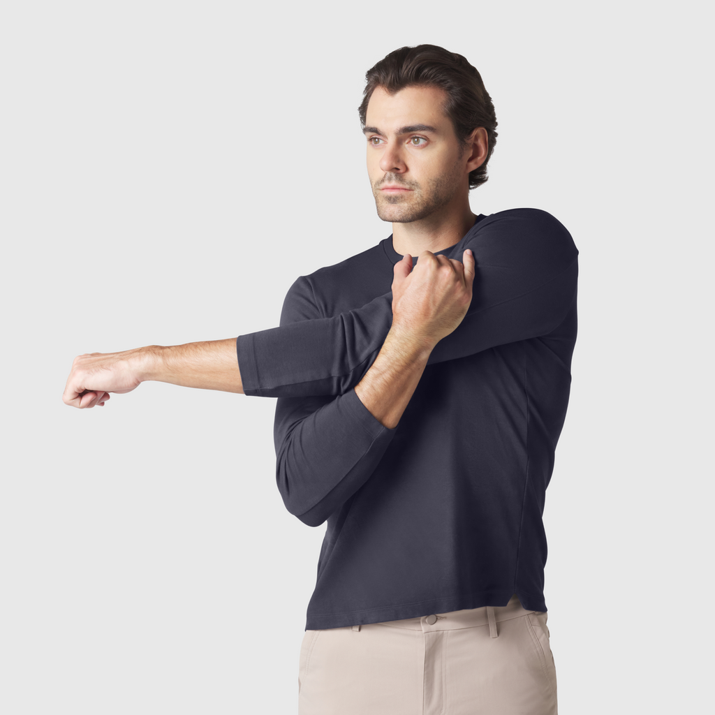 Precision Long Sleeve Tee in organic cotton, emphasizing shoulders, worn by male model stretching arm.